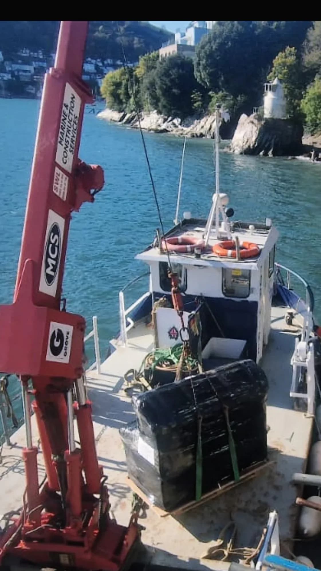 Crane and packaged sauna components aboard the delivery boat on the River Dart