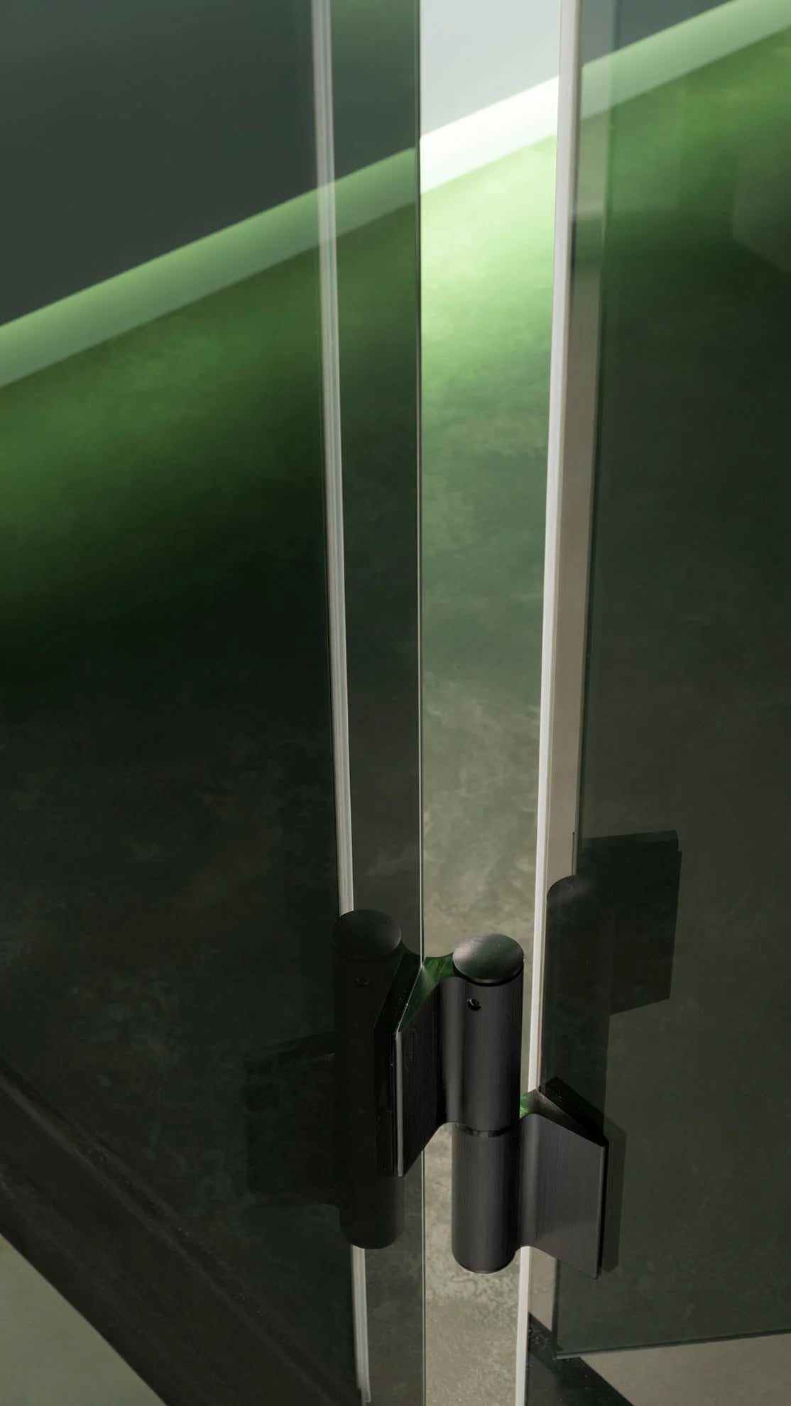 Soft-close glass hinge detail on an INFINITY steam room
