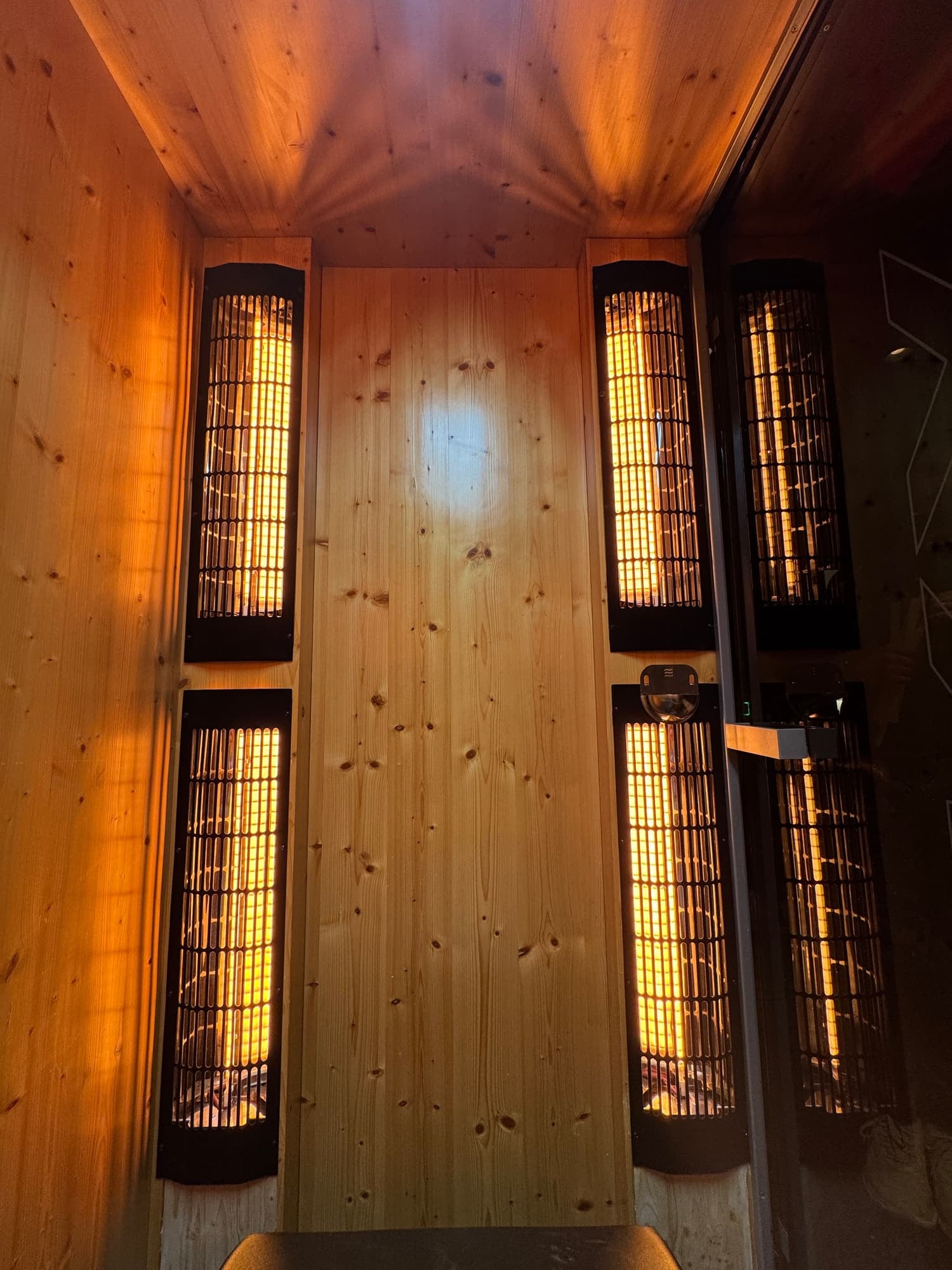 Infrared heaters mounted on a wooden wall in a sauna or spa room.