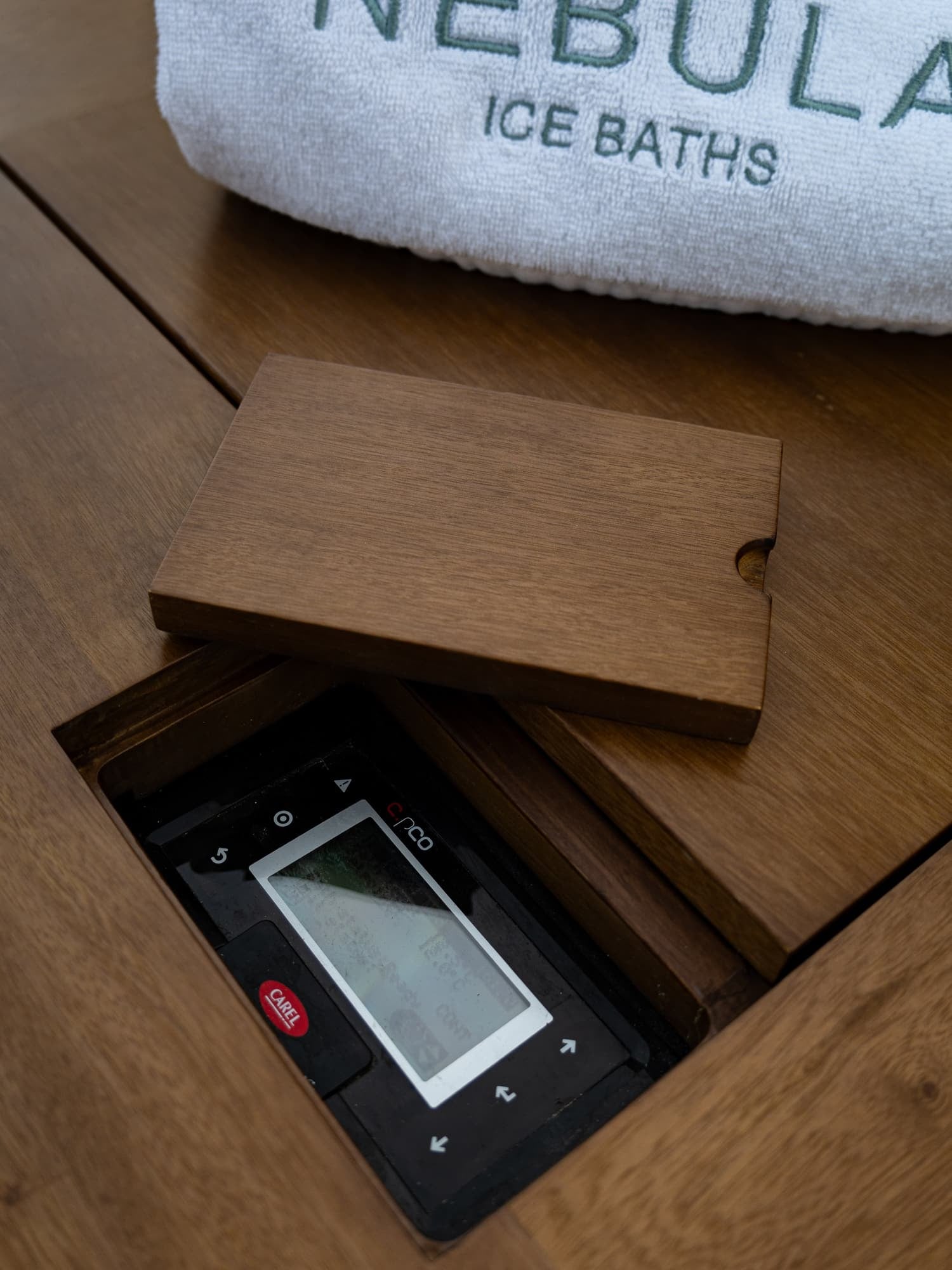 Carel control panel under its teak cover, beside a Nebula towel