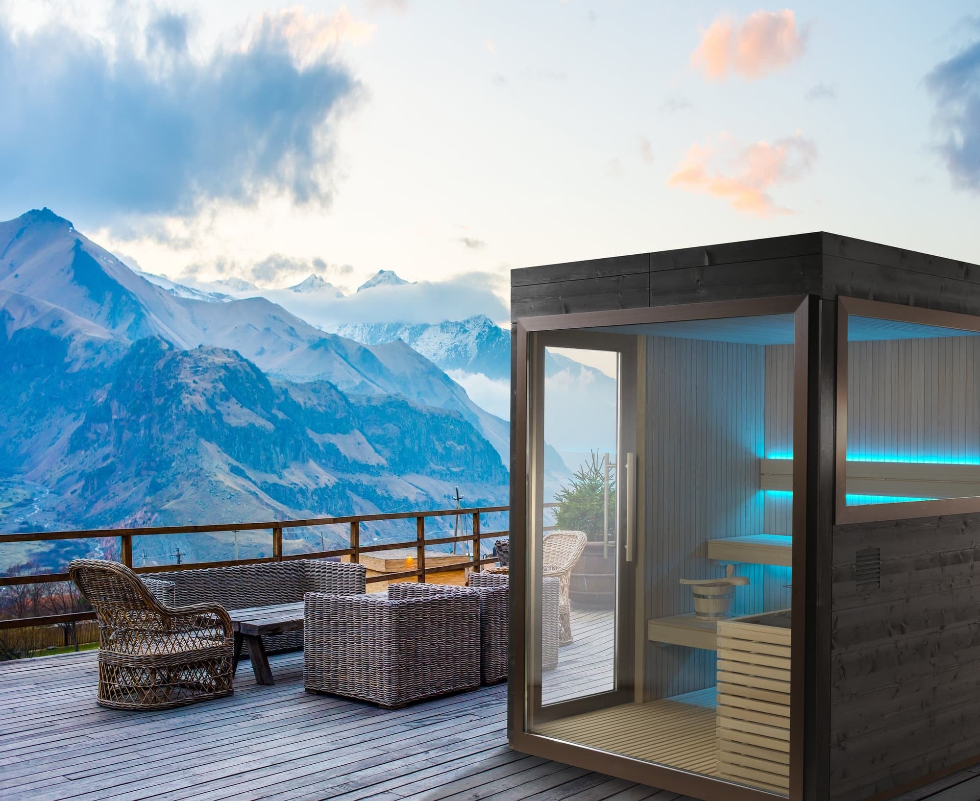 Outdoor sauna with illuminated timber benches beside an alpine terrace